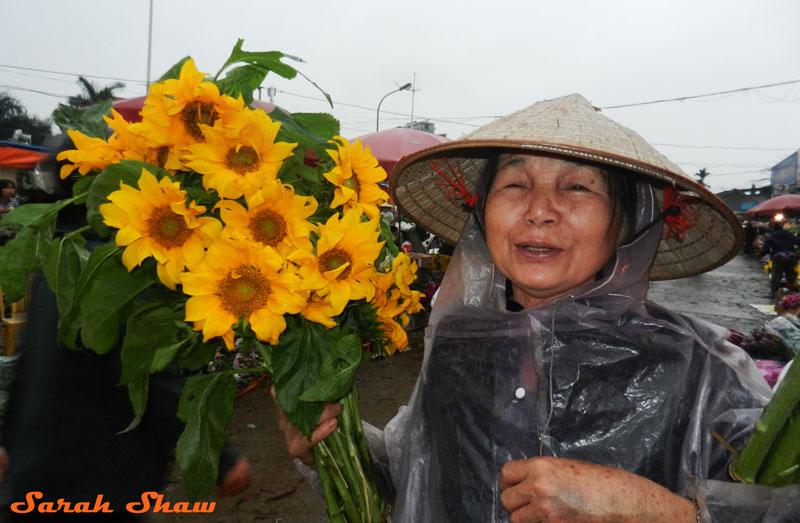 A woman buys sunflowers at Hanoi's flower market