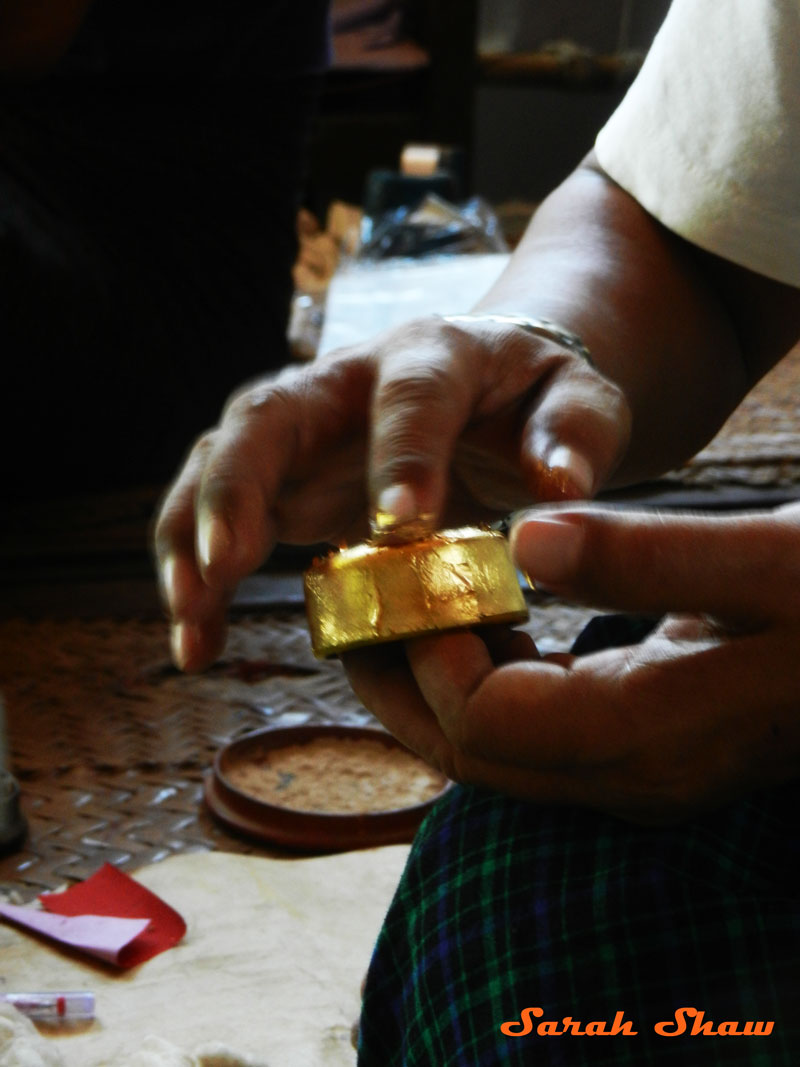 Adding gold leaf to a lacquer dish in Bagan, Myanmar