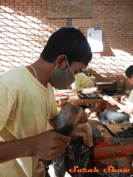 An apprentice carves at Artisans Angkor in Siem Reap