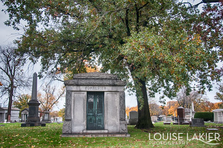 A Mausoleum sits under the shade of a tree in Oakwoods Cemetary