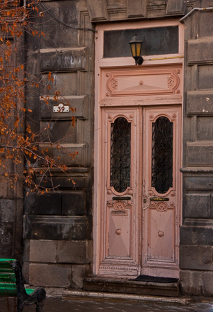 Pnk door and green bench in Gyumri