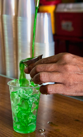 Pouring green rum vertical