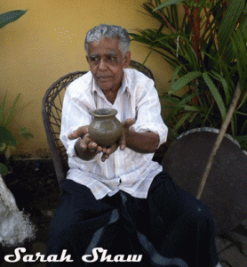 The potter shows off his finished pot in Kerala