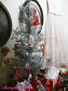 A tinsel tree is decorated with vintage cookie cutter