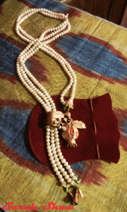 Lariat necklace of pearls with a pomegranate slide