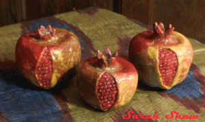 Ceramic pomegranates accented with ruby seeds