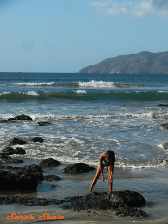 A girl collects seashells in Tamarindo, Costa Rica