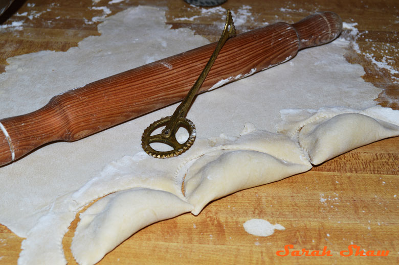 Sealing Gazelles' Horns cookies with astry wheel