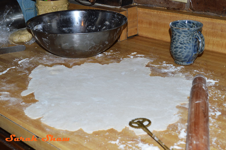 Pastry dough rolled out on a floured surface