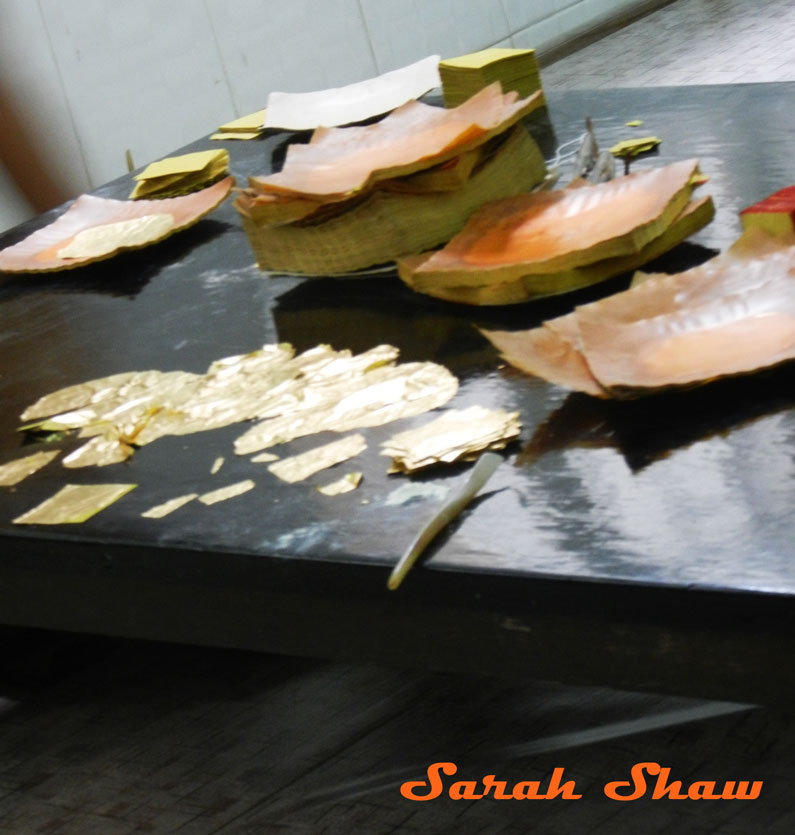 Trimming and packaging gold leaf in Mandalay, Myanmar