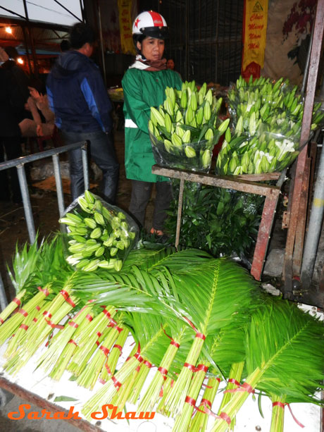Palm fronds for sale with lillies at the Hanoi Flower Maket, Vietnam