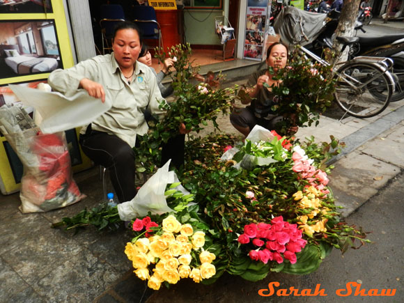 Sidewalk florists offer flowers to passers by in Hanoi. Vietnam