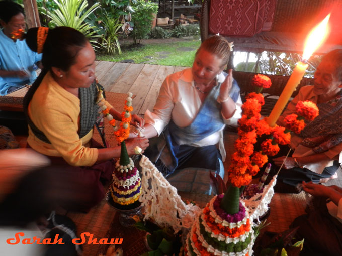 Tying on strings in a baci ceremony in Luang Prabang, Laos