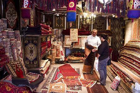 Turkish Man Selling Carpet to Female Tourist